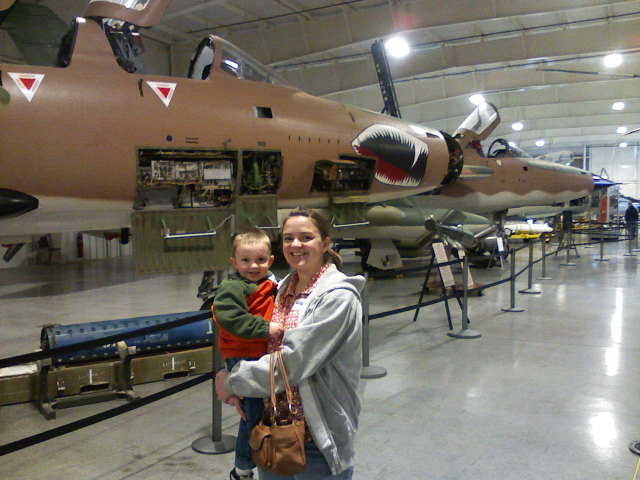 Maggie and Patrick in front of a fighter jet.